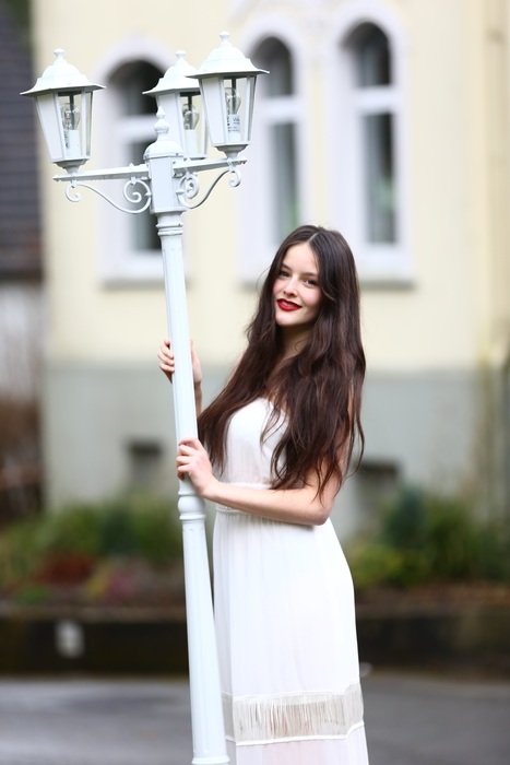 girl in white dress with white lantern on the street in Germany