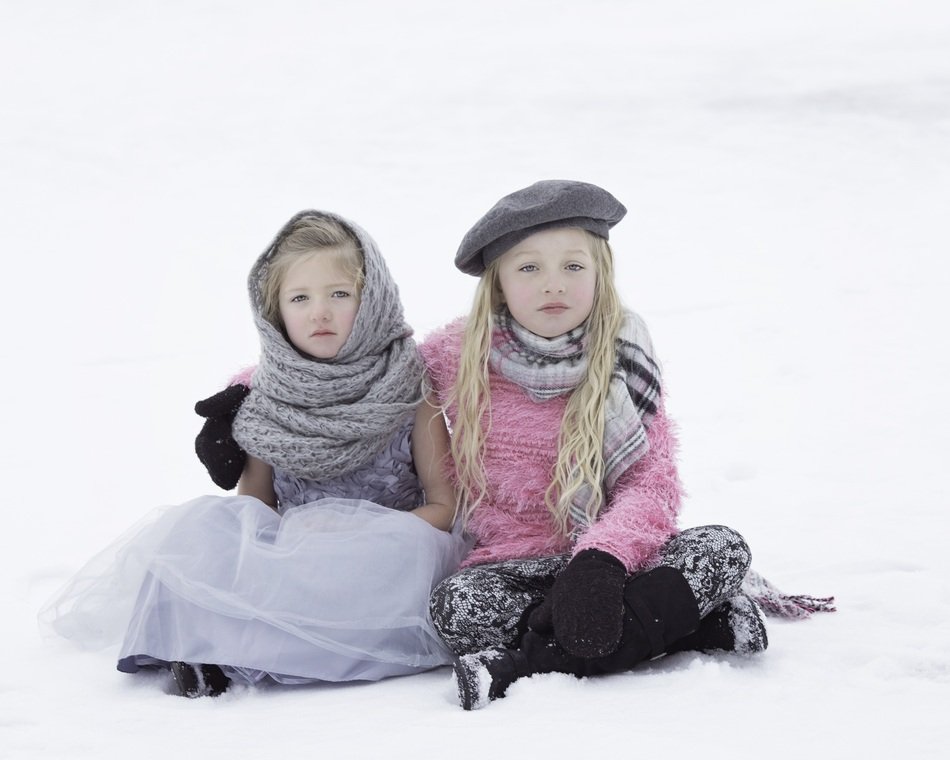 Sisters, two Child Girls sitting on snow