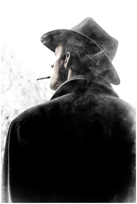a man in a hat with a cigarette