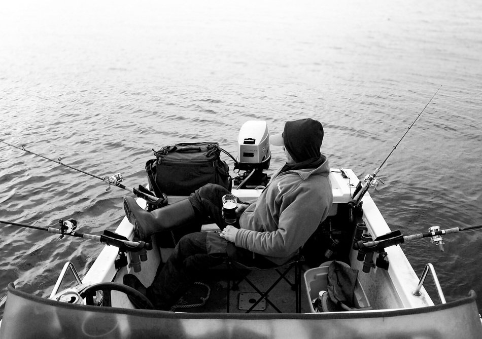 Man Fishing with rods in Boat, black and white image