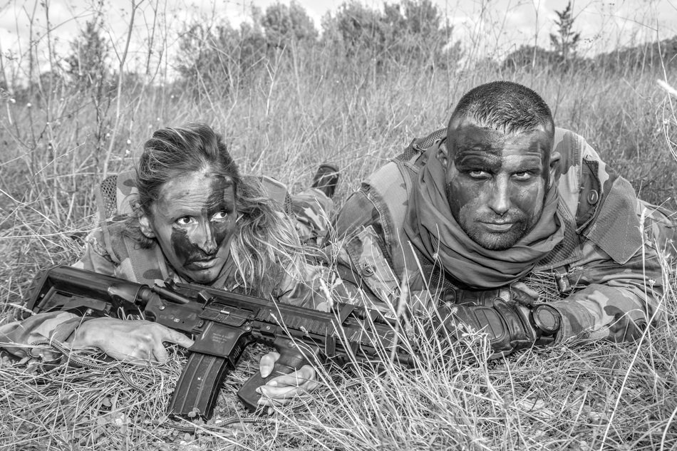 soldiers in uniform in tall grass in black and white image