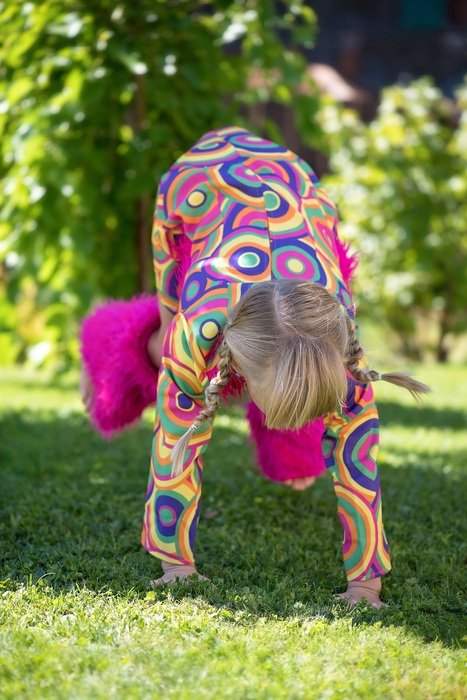 baby girl doing somersault on grass