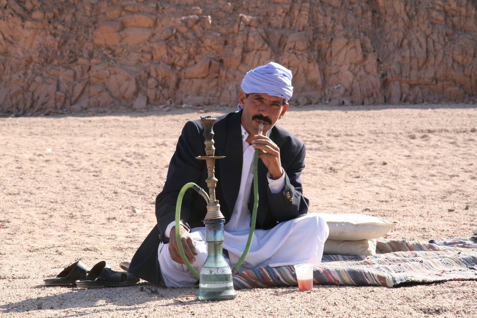 man with a hookah in the desert in India