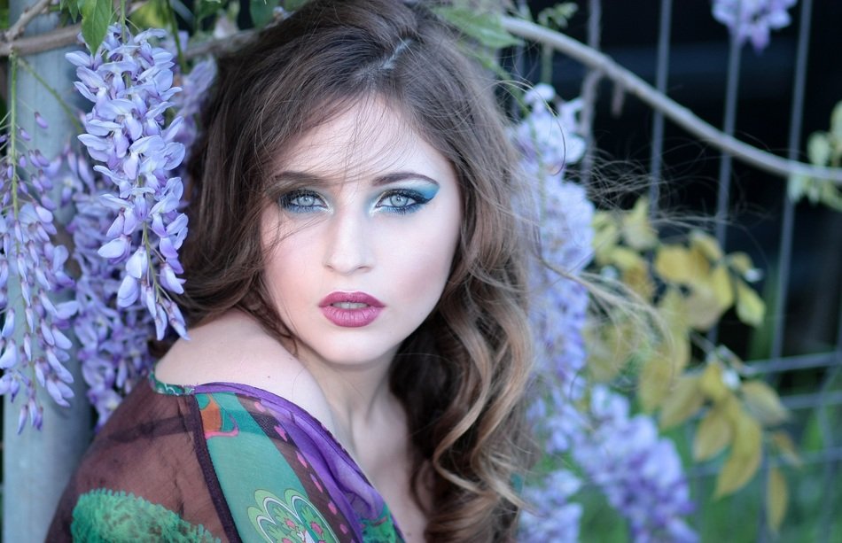 sensual woman with blue eyes among the colorful plants