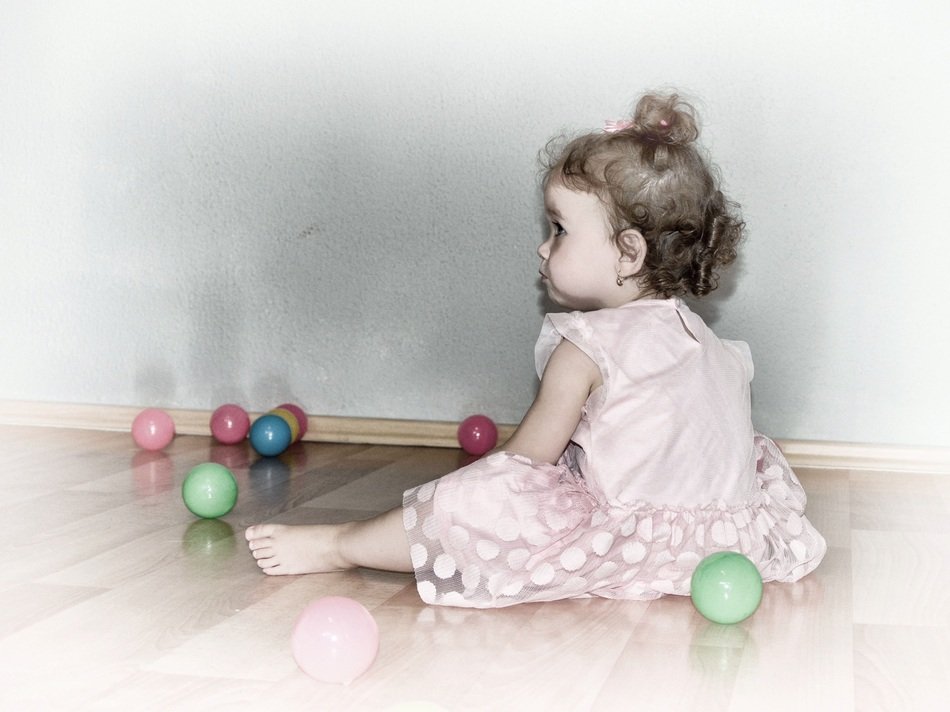 cute curly girl on the floor with balls