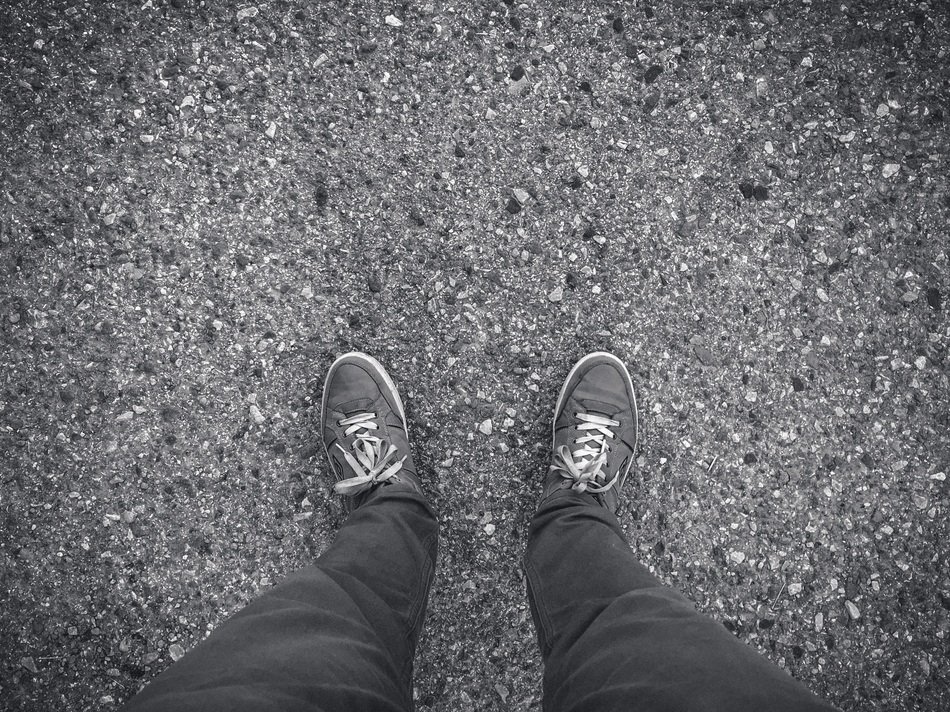 Manâs Feet in Sneakers on Concrete