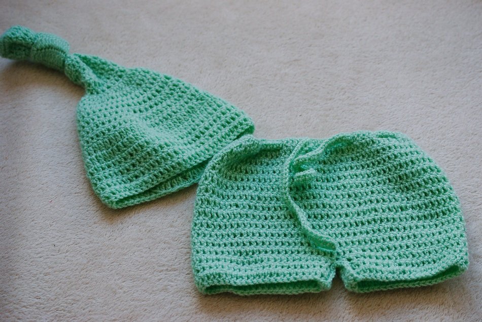 green knitted baby shorts and cap