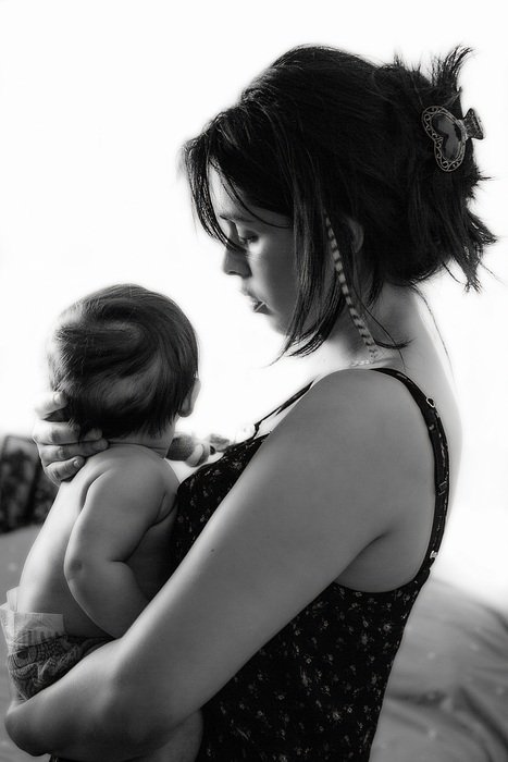 black and white image of a young mother with a baby
