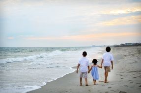 brothers and sister walking on the beach