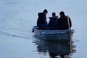 three men in boat on lake at winter