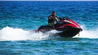 young man on a red jet ski at sea