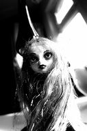 monochrome picture of doll with big eyes and long hair