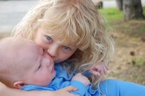 girl kisses baby brother