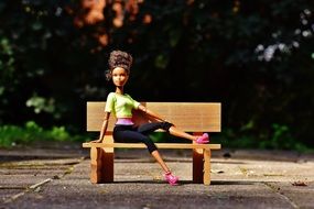 Doll on a park bench with a raised leg