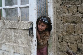 little gypsy girl in the doorway of an old house