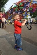 little boy with a multi-colored umbrella