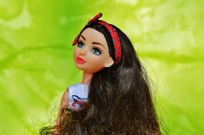 doll with long brown hair and a bandage on them