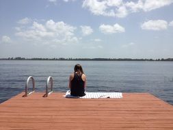 girl on the pier near the lake on a sunny day