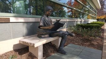 statue on a bench near the library