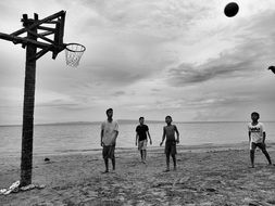 black and white photo of children's basketball game on the sandy beach