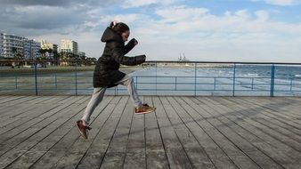 girl jumping for joy on the waterfront