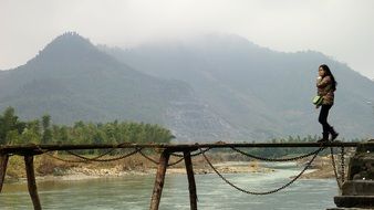 Chinese woman cross a narrow bridge