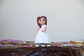 figurine girl in a white dress on the cake