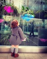 Cute kid standing near the glass