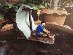 boy on a raft in water in a flower pot