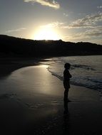 child at sunset by the sea