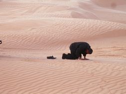 Muslim man Praying in sand Desert