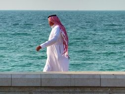 Person in the Muslim clothing on the seashore