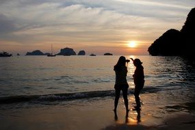 tourists on the beach at dusk of a bright sunset