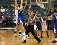 jumping basketball players and referee