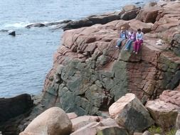 people sit on the edge of the cliff