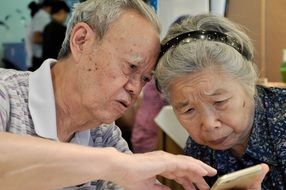elderly couple with a phone