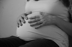 woman hands on the pregnant belly, black and white