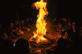 people around the fire in the dark