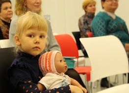 little girl with a doll in her hands