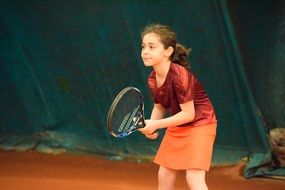 girl plays tennis on the court