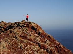 the man in red at the top of the cliff