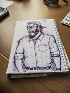 sketch of a man in a notebook on the table