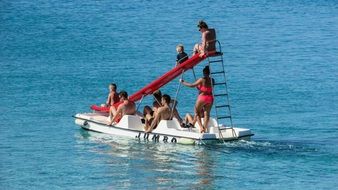 people on a catamaran with a slide in the sea on the coast of Protaras, Cyprus