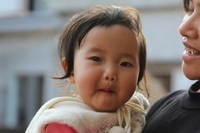 photo of vietnamese little girl with the mother on blurred background