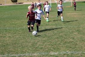 boys in uniform play soccer