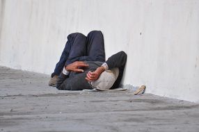 A homeless man sleeping on the concrete