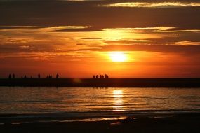 landscape of the silhouette of people on pier at sunset