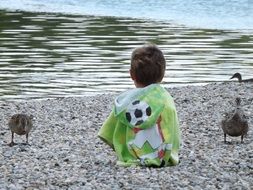 baby and ducks by the lake