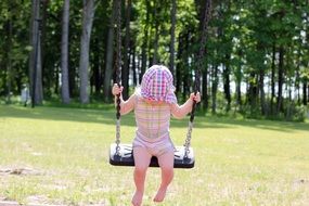 Child on the swing in summer