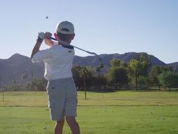 boy is playing golf on the field